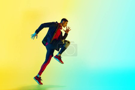 Photo for Dynamic image of young athletic man in sportswear, training, running against gradient blue yellow background in neon light. Concept of active and healthy lifestyle, sport, fitness, endurance - Royalty Free Image