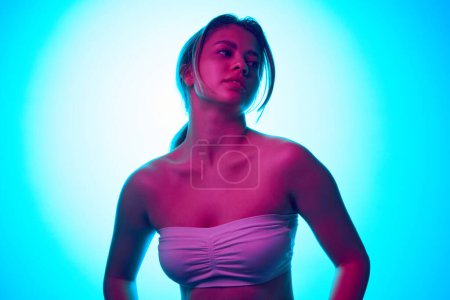 Photo for Attractive young blonde beautiful girl in white strapless top posing against gradient studio background in neon light. Wellness. Concept of beauty, skincare, cosmetics and cosmetology - Royalty Free Image