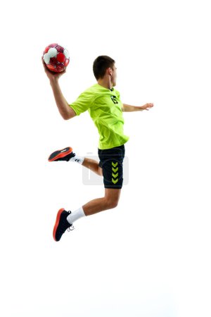 Photo for Full-length image of young handball athlete in motion during game, throwing ball against white studio background. Motivation to win. Concept of professional sport, tournament, competition - Royalty Free Image