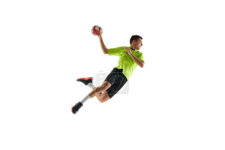 Photo for Concentrated and motivated young man, handball player in motion during game, training, playing against white studio background. Concept of professional sport, tournament, competition - Royalty Free Image