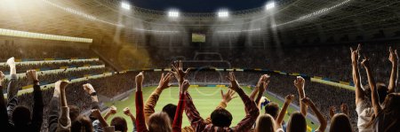 Photo for Back view of emotional football fans cheering favorite soccer team at crowded open air stadium at evening time during game. Concept of competition, leisure time, emotions, live sport event - Royalty Free Image