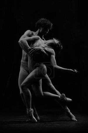 Foto de Hermosa pareja joven, hombre y mujer, bailarines de ballet haciendo rendimiento creativo. Imagen en blanco y negro. Concepto de arte clásico, estética, emociones, danza de ballet, talento - Imagen libre de derechos