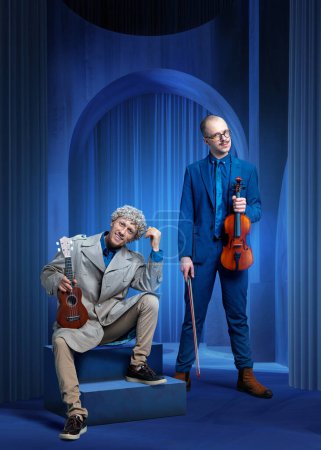 Zwei Männer in Anzügen, Musiker mit Geige und Ukulele treten in einem blau inszenierten Raum auf. Luxusveranstaltung mit klassischer Live-Musik. Konzept von Musik, Performance, Kunst, Talentshow, Inspiration. Poster