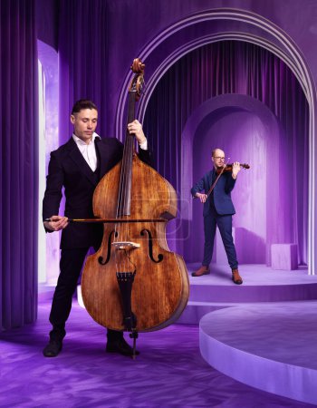 Zwei talentierte, künstlerische Männer im klassischen Anzug spielen Kontrabass und Geige gegen luxuriöse, kreative lila Zimmer. Tiefe Musik. Konzept von Musik, Performance, Kunst, Talentshow, Inspiration. Poster