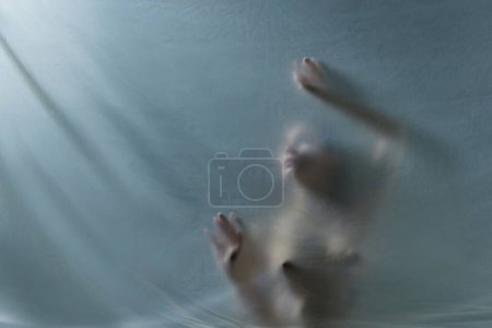 Téléchargez les photos : Peurs intérieures et auto-soin. Silhouette de jeune femme posant nue, appuyée sur du verre transparent, mat et texturé. Concept d'esthétique corporelle, féminité, beauté, santé, art - en image libre de droit