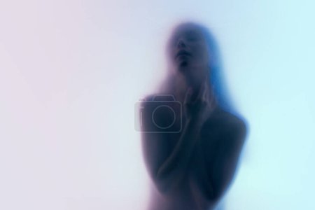 Téléchargez les photos : Silhouette de tendre jeune femme posant nue sur fond néon clair dégradé. Image floue. Monde intérieur. Concept d'esthétique corporelle, féminité, beauté, santé, art - en image libre de droit