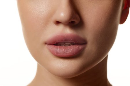 Photo for Cropped close-up image of beautiful female face, plump lips with nude lipsticks makeup isolated against white studio background. Lip augmentation. Concept of beauty, cosmetology, cosmetics, skin care - Royalty Free Image