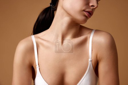 Photo for Cropped portrait of young female model demonstrate her well-kept smooth decollate zone against grey studio background. Concept of beauty, spa procedures, dermatology treatments, cosmetology care. - Royalty Free Image