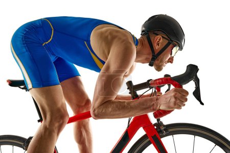 Photo for Competitive young man in blue uniform training, riding bicycle, developing speed isolated on white studio background. Concept of sport, active and healthy lifestyle, speed, endurance, hobby - Royalty Free Image