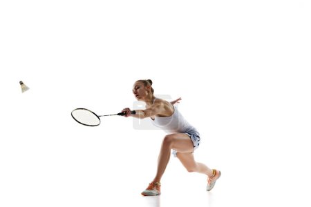 Photo for Young sportive girl, badminton player in motion, training, playing isolated over white background. Endurance and persistence. Concept of professional sport, active lifestyle, hobby, game - Royalty Free Image