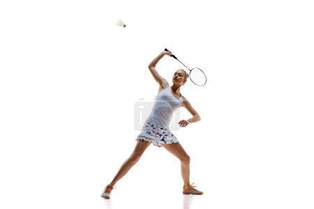 Photo for Concentrate young woman, badminton athlete in motion playing isolated over white background. Winning game. Concept of professional sport, active lifestyle, hobby, game - Royalty Free Image