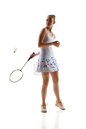 Photo for Playing techniques. Young girl, badminton player training, playing isolated over white background. Active lifestyle. Concept of professional sport, active lifestyle, hobby, game - Royalty Free Image