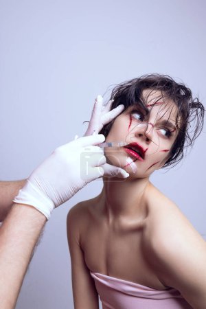 Foto de Aumento de labios. Mujer joven haciendo tratamiento de belleza facial, visitando cosmetólogo para hacer los labios más gruesos. Concepto de estándares modernos de belleza, cirugía plástica, salud, cosmetología - Imagen libre de derechos