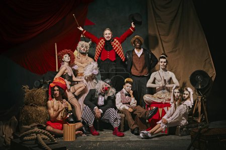 Photo for Diverse cast of vintage circus performers poses over dark retro circus backstage background. Promotional poster for upcoming performances. Concept of circus, theater, performance, show, retro and - Royalty Free Image