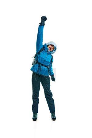 Photo for Excited young woman, hiker in jacket, gloves and goggles jumping isolated on white background. Comfortable and necessary clothes. Concept of active lifestyle, tourism, mountaineering, sport, travel - Royalty Free Image