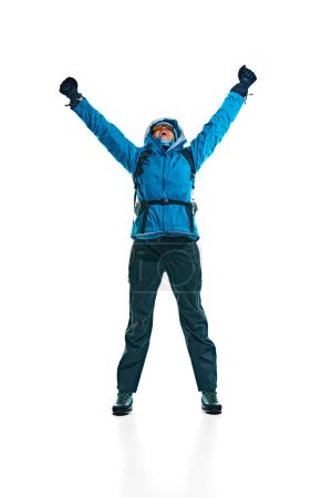 Photo for Happy young woman, hiker in jacket, gloves and goggles jumping isolated on white background. Comfortable and necessary clothes. Concept of active lifestyle, tourism, mountaineering, sport, travel - Royalty Free Image
