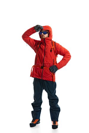Photo for Male tourist wearing warm jacket, goggles and backpack for comfortable mountain climbing isolated on white background. Concept of active lifestyle, tourism, mountaineering, sport, travelling - Royalty Free Image