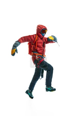 Photo for Winter tourism. Man wearing protective goggles, gloves, boots and special equipment for mountain climbing isolated on white background. Concept of active lifestyle, tourism, mountaineering, sport - Royalty Free Image