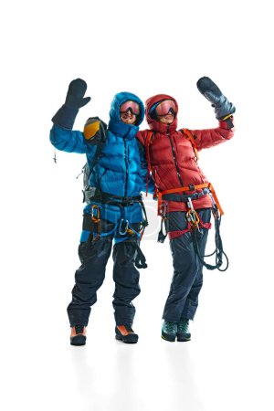 Téléchargez les photos : L'équipe. Homme et femme en équipement spécial d'alpinisme. Veste, bottes, lunettes et sac à dos isolés sur fond blanc. Concept de mode de vie actif, tourisme, alpinisme, sport, voyage - en image libre de droit