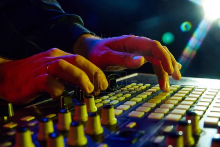 Photo for Electronic music, party and night club entertainment. Close-up of dj mixer, man adjusting sounds and beats on dark background with stage lights. Concept of music, concert, sound, equipment, festival - Royalty Free Image