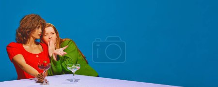 Junge rothaarige Frau trinkt Cocktail und spricht mit Schaufensterpuppe vor blauem Hintergrund. Freunde treffen sich, reden Gerüchte, lachen. Konzept der Pop-Art-Fotografie, Kreativität