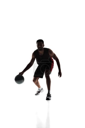 Photo for Athletic young man, basketball player in motion with ball, training, playing isolated on white background. Silhouette. Concept of professional sport, competition, game, tournament, action - Royalty Free Image