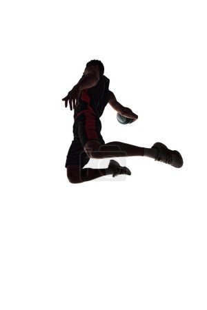 Photo for Spirit of competitive sports. Silhouette of basketball player in motion with ball during jump isolated on white background. Concept of professional sport, competition, game, tournament, action - Royalty Free Image