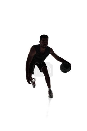 Photo for Concentration and focus. Male basketball player in motion during game, training isolated on white background. Silhouette. Concept of professional sport, competition, game, tournament, action - Royalty Free Image