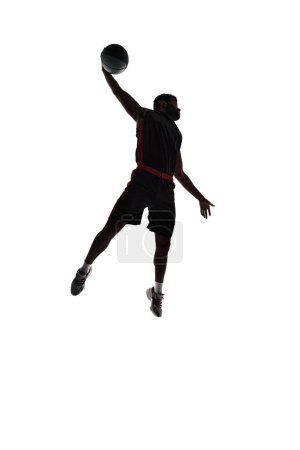 Photo for Full-length silhouette of male basketball player, athlete in motion during game, making winning moment isolated on white background. Concept of professional sport, competition, game, tournament - Royalty Free Image