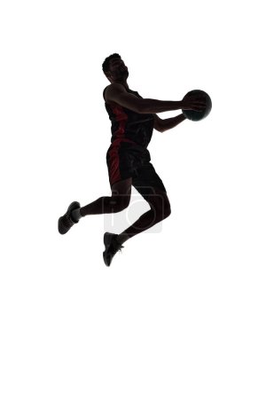 Foto de Silueta de jugador de baloncesto masculino en movimiento durante el juego, entrenamiento, jugando aislado sobre fondo blanco. De larga duración. Concepto de deporte profesional, competición, juego, torneo, acción - Imagen libre de derechos