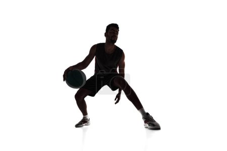 Photo for Silhouette of concentrated male athlete, basketball player in motion, dribbling ball isolated on white background. Concept of professional sport, competition, game, tournament, action - Royalty Free Image