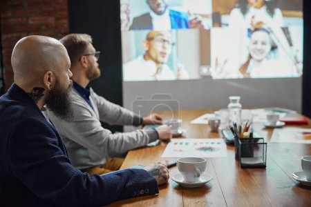 Photo for Team leader and project manager sitting in office and having online conference call with employees. Discussion of projects and working on tasks. Business, teamwork, cooperation with colleagues concept - Royalty Free Image