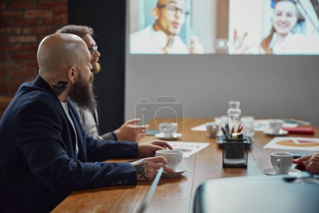 Photo for Business people, project managers having online conference video call on tv screen with diverse company employees. Concept of business, teamwork, cooperation with colleagues - Royalty Free Image