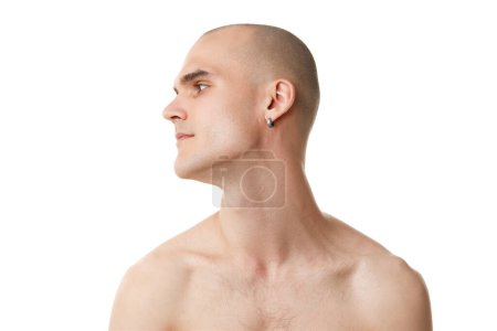 Téléchargez les photos : Portrait de jeune homme torse nu avec tête chauve et visage rasé immaculé isolé sur fond de studio blanc. Concept de soins de la peau, beauté masculine, bien-être, cosmétique, auto-soin - en image libre de droit