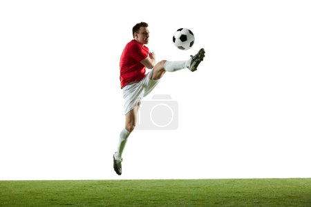 Photo for Dynamic image of young man, football player in motion with ball during game isolated on white background. Concept of professional sport, game, competition, tournament, action, active lifestyle - Royalty Free Image