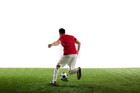 Photo for Man, football player in motion during game training, running on filed with ball isolated on white background. Concept of professional sport, game, competition, tournament, action. Back view - Royalty Free Image