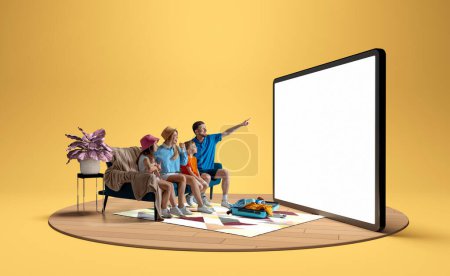 Photo for Family, man, woman and children sitting on sofa at home and pointing at giant 3D model of tablet, booking hotels and tickets via online services. Concept of business, Internet, travelling - Royalty Free Image