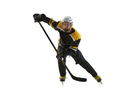 Foto de Hombre enfocado y motivado, jugador de hockey con uniforme protector y casco, entrenamiento, compitiendo aislado sobre fondo blanco. Concepto de deporte profesional, competición, juego, torneo - Imagen libre de derechos