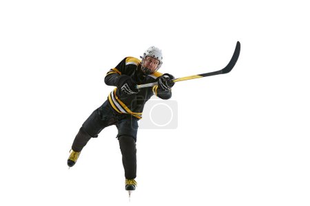 Téléchargez les photos : Homme concentré, joueur de hockey en mouvement avec bâton, jouant, s'entraînant isolé sur fond blanc. Concept de sport professionnel, compétition, jeu, tournoi - en image libre de droit