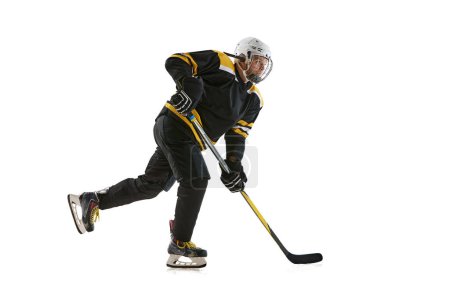 Photo for Young man wearing black and yellow uniform, hockey player in motion with stick during game isolated on white background. Concept of professional sport, competition, game, tournament - Royalty Free Image