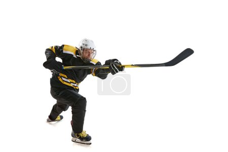 Foto de Joven competitivo, jugador de hockey en movimiento durante el juego, entrenamiento, compitiendo aislado sobre fondo blanco. Concepto de deporte profesional, competición, juego, torneo - Imagen libre de derechos
