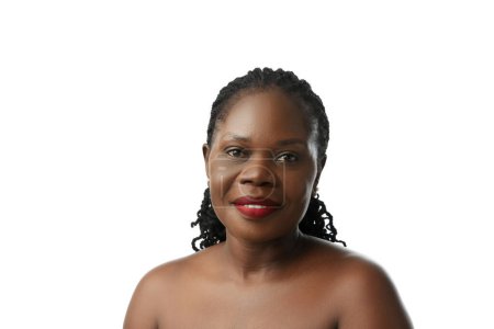 Foto de Retrato de una mujer africana adulta hermosa con labios rojos, piel clara e impecable sonriendo aislada sobre fondo blanco del estudio. Concepto de belleza natural, cuidado de la piel y del cuerpo, cosmetología, cosmética - Imagen libre de derechos
