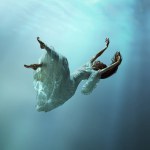 Angelic young girl in tender dress immersed in a world of tranquility and freedom. Girl levitating underwater with calmness. Concept of surrealism, beauty, mystery and fantasy, freedom