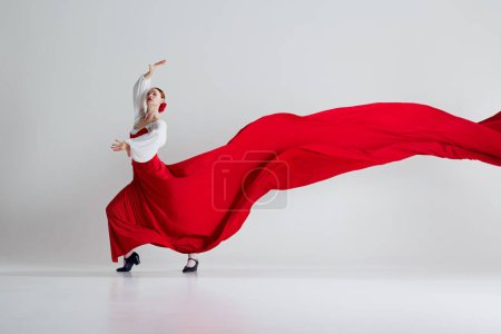 Photo for Stunning moment captures t essence of flamenco. Female dancer in red costume red in dramatic flourish symbolizing intense emotion of performance. Concept of art of movement, classical dance, beauty - Royalty Free Image