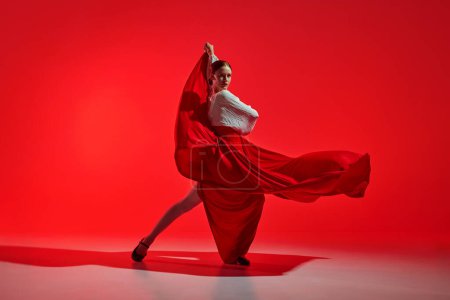 Photo for Beautiful woman, performing flamenco with grace, dynamic movements reflecting fiery heart of traditional Spanish dance. Concept of art of movement, classical dance, beauty, festival - Royalty Free Image