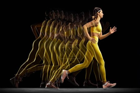 Foto de Mujer joven atlética en ropa deportiva amarilla capturada en movimiento, entrenando, corriendo sobre fondo negro con efecto estroboscópico. Concepto de deporte, estilo de vida activo y saludable, resistencia y fuerza - Imagen libre de derechos