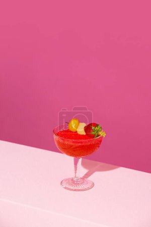 Photo for Human hand holding sweet and sour fruity cocktail with berries against pink background. Summer vacation. Concept of alcohol and non-alcohol drink, party, holidays, bar, mix. Poster. Copy space for ad - Royalty Free Image