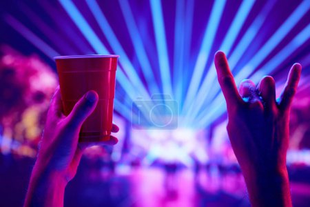 Foto de Rock and roll live concert event. People attending live concert, having fun, drinking beer, dancing. Concept of party, celebration, leisure activity, fun, night life - Imagen libre de derechos