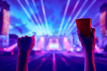 Téléchargez les photos : Concert Rock and roll en direct. Les gens assistent à un concert, s'amusent, boivent de la bière, dansent. Concept de fête, célébration, loisirs, plaisir, vie nocturne - en image libre de droit