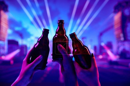 Photo for Cheers. Friends gathering at night to have fun. attending nightclub, dancing, drinking beer and enjoying. Concept of party, celebration, leisure activity, fun, night life - Royalty Free Image